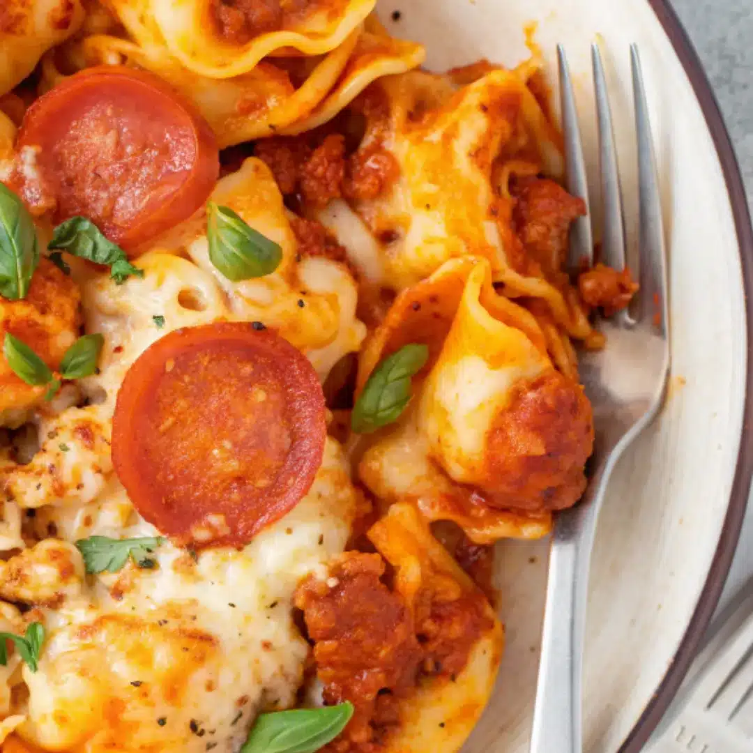 Serving Cheese Tortellini Pepperoni Pizza Casserole Serving bowl of Cheese Tortellini Pepperoni Pizza Casserole with gooey cheese and crispy pepperoni