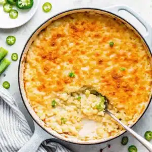 Jalapeno Mac n Cheese – The Ultimate Spicy Comfort Food Recipe Guide 7 Baked jalapeno mac n cheese in a white enameled skillet with a serving spoon