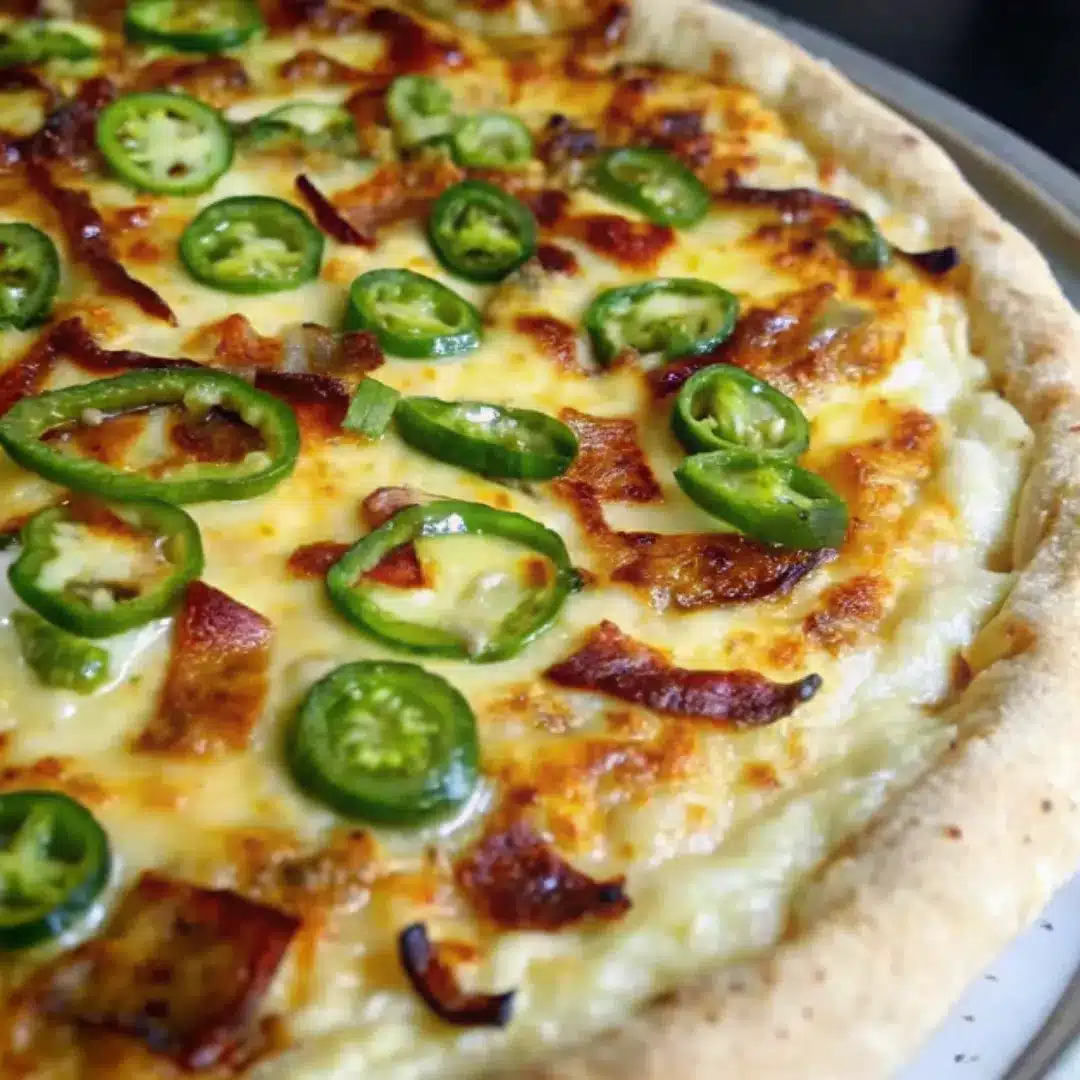 Spicy Jalapeño Popper Pizza with Crispy Beef Bacon Jalapeño popper pizza topped with melted cheese, sliced jalapeños, and beef bacon on a golden crust.
