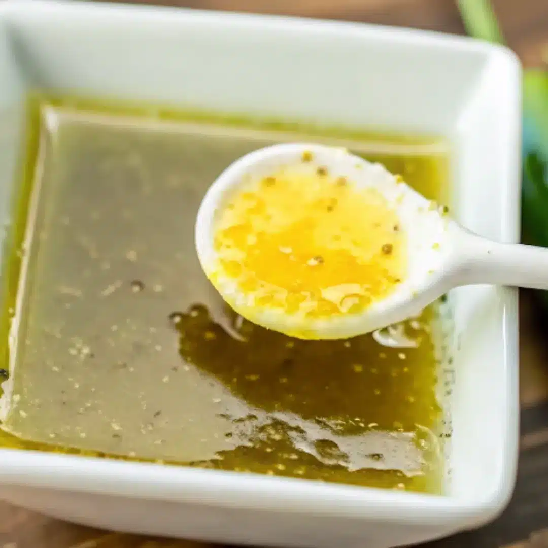 Jam with Jalapeño – Sweet, Spicy, and Irresistibly Unique Spoonful of golden jalapeño jam over a square white dish with green pepper-infused jelly