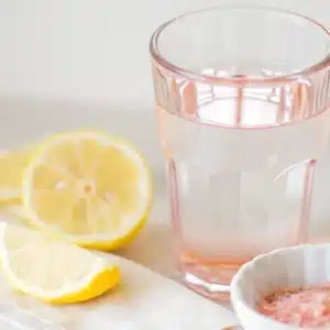 Pink Salt Electrolyte Drink – Benefits, Uses & How to Make It 2 pink salt electrolyte drink with lemon slices on a white background