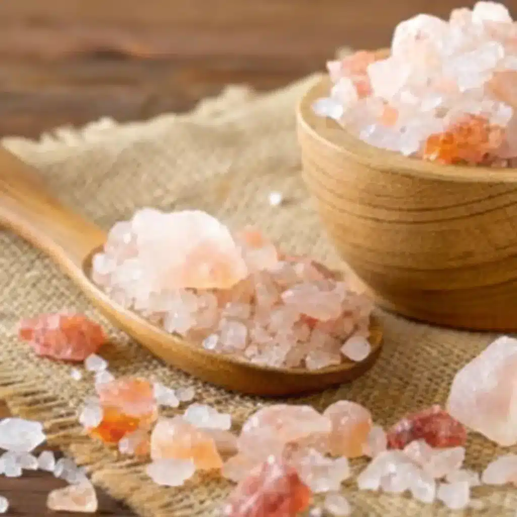 Pink Salt Mounjaro Crystals in Wooden Bowl and Spoon Pink salt mounjaro crystals in wooden bowl and spoon on burlap cloth