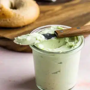 Jalapeno Cream Cheese: The Bold, Creamy Spread You’ll Crave Daily 12 Jar of creamy green cheese spread with knife, bagel in background