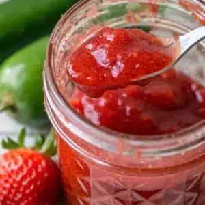 Strawberry Jalapeno Jam – The Sweet and Spicy Twist You Need to Try 8 spoonful of homemade strawberry jalapeno jam lifted from a glass jar