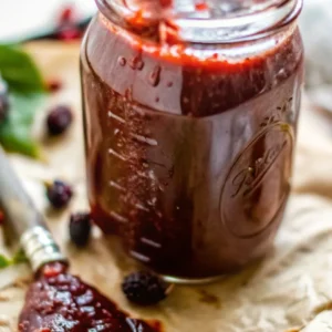 Blackberry Jalapeno Sauce: The Sweet and Spicy Twist You Need in Your Kitchen 1 Jar filled with blackberry jalapeno sauce on parchment with berries